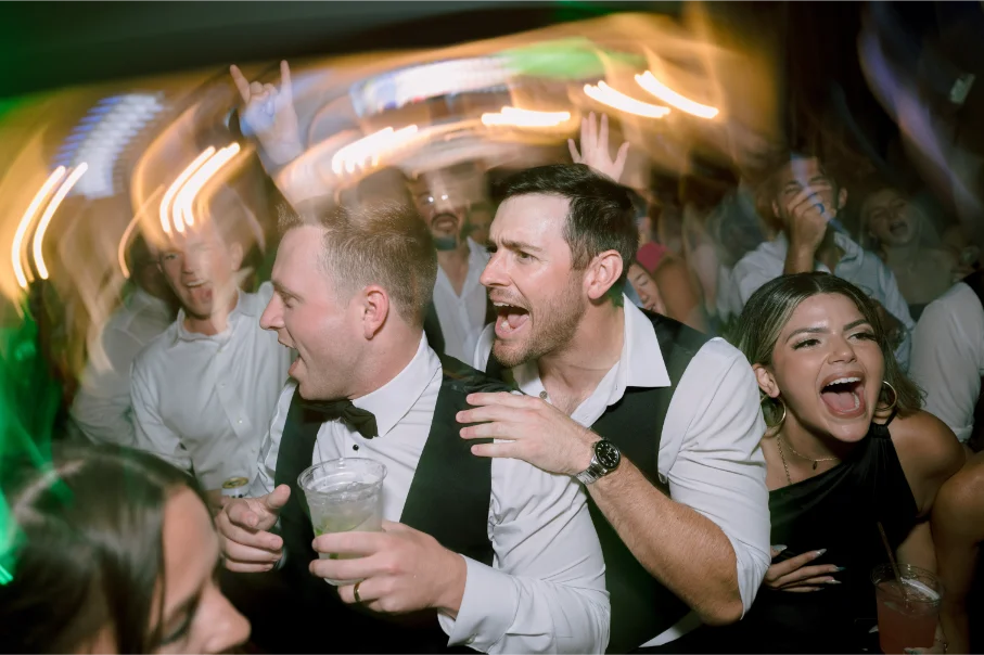 Groomsmen dancing surrounded by beautiful ladies, motion light shot.