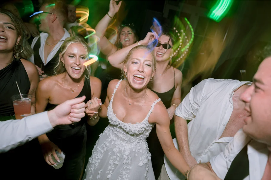 Bride dancing in the center surrounded by family and friends, on a high energy dance floor.