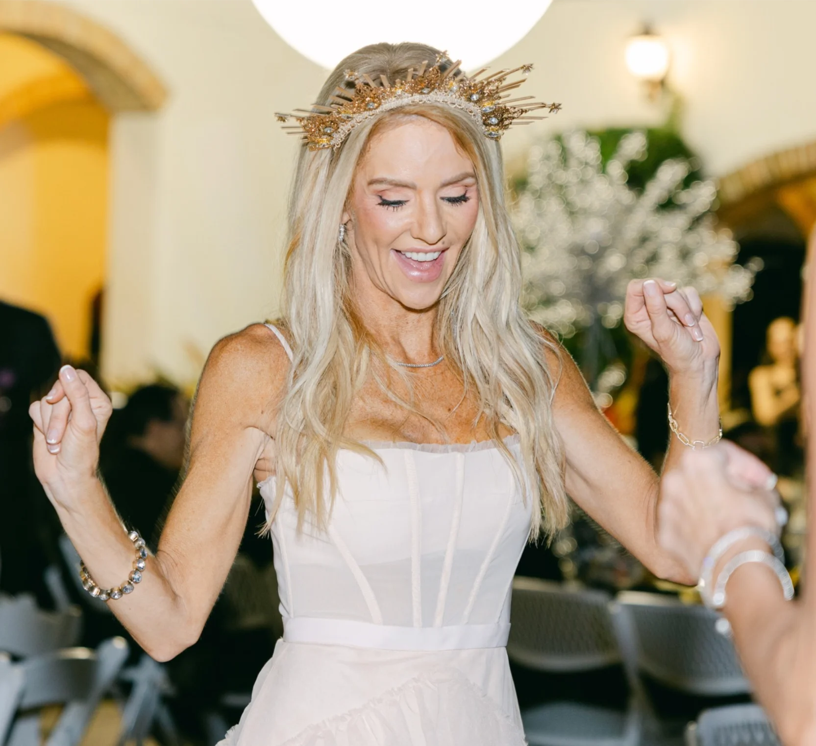 Beautiful bride with gold crown dancing in Talis Park.